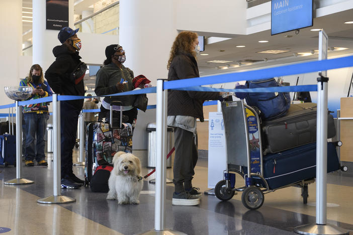 Travelers wait to check baggage for an American Airlines flight at Los Angeles International Airport on Wednesday. The Centers for Disease Control and Prevention is urging people to not travel for Thanksgiving.