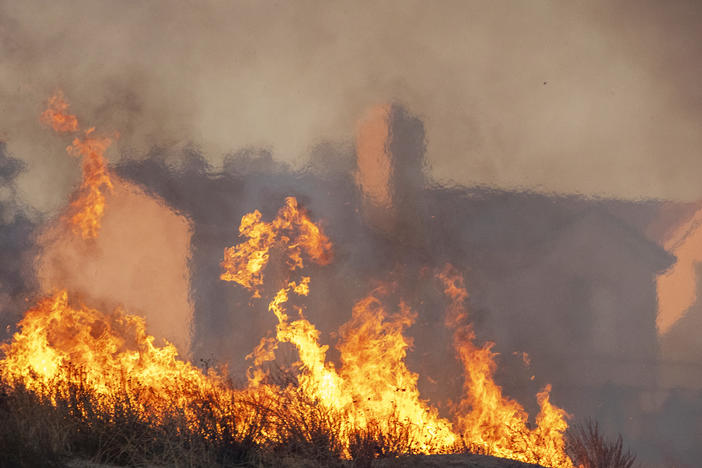 Flames approach houses during the Tick Fire on Oct. 24, 2019 in Canyon Country, California.