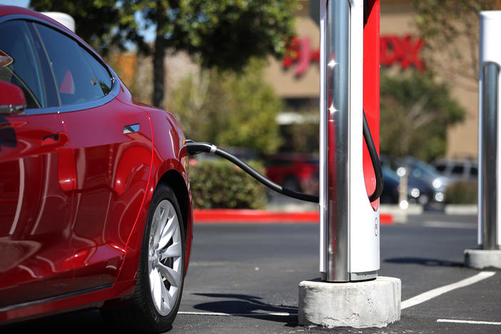 A Tesla car powers up at a charging station in Petaluma, Calif., on Sept. 23. Automakers are trying to convince would-be electric car buyers to adopt new habits to power their vehicles.