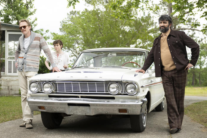 L to R: Frank (Paul Bettany) Beth (Sophia Lillis) and Walid (Peter Macdissi) pull up to the bumper in <em>Uncle Frank</em>.