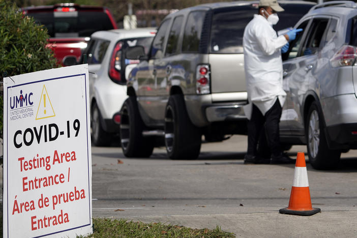 A healthcare worker processes people in line at a United Memorial Medical Center COVID-19 testing site on Nov. 19, in Houston. Texas is rushing thousands of additional medical staff to overworked hospitals as the number of hospitalized COVID-19 patients increases.