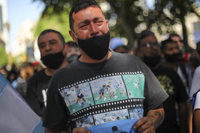 A man cries as he waits in a line outside the presidential palace to pay his final respects to Diego Maradona, in Buenos Aires on Thursday.
