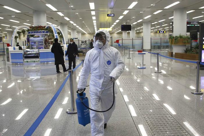 North Korean State Commission of Quality Management staff in protective gear carries a disinfectant spray can as personnel check the health of travelers and inspect goods delivered via the borders at the Pyongyang Airport in North Korea, on Feb. 1.