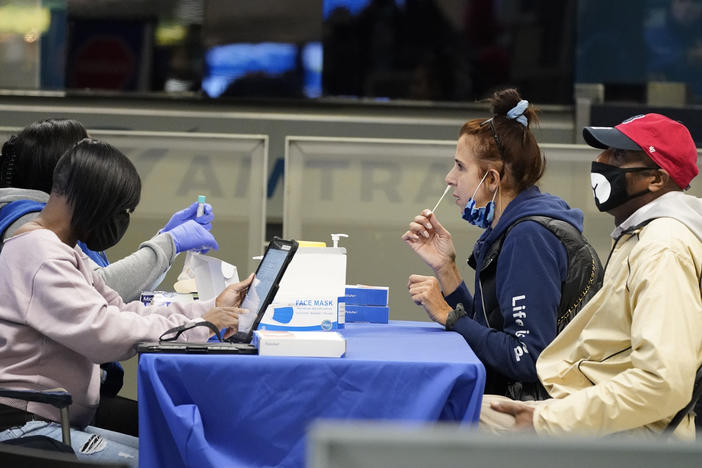 Travelers self-test for the coronavirus at a mobile testing site at New York City's Penn Station in the days leading up to Thanksgiving. The U.S. is currently seeing record hospitalizations for COVID-19, and health experts fear more surges are on their way.