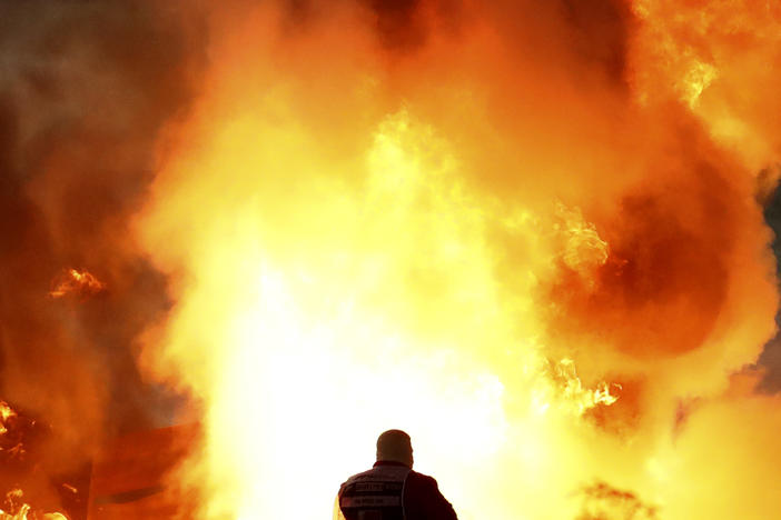 Staff extinguish flames from Haas driver Romain Grosjean of France's car after a crash during the Formula One race in Bahrain International Circuit in Sakhir, Bahrain, Sunday.