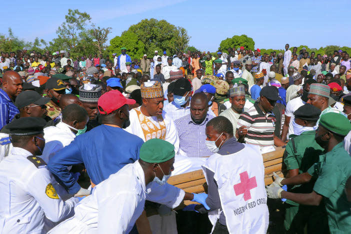 People attend a funeral for those killed by suspected Boko Haram militants in Zabarmari, Nigeria on Sunday. Officials say armed men on motorcycles reportedly killed at least 70 rice farmers and fishermen while they were harvesting crops in northern Borno state.
