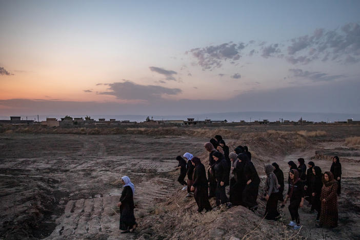 Survivors of the ISIS genocide of Yazidis walk to mass graves near the village of Kocho, northern Iraq, in August 2019, on the fifth anniversary of the massacre that killed most of the men and older boys in the village.