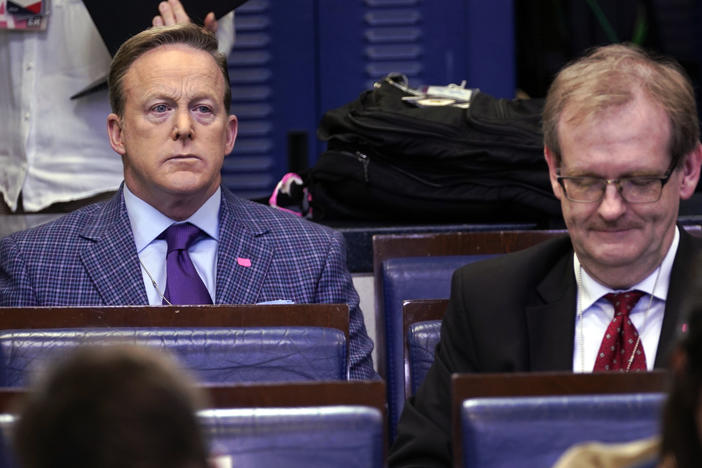 Sean Spicer (left), the former White House press secretary and an on-air personality for Newsmax, listens during a March coronavirus task force briefing at the White House.
