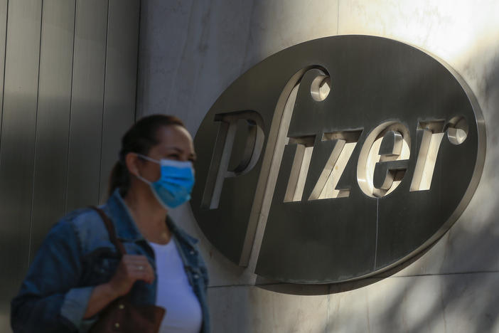 A woman wears a mask as she walks by Pfizer's world headquarters in New York last month.