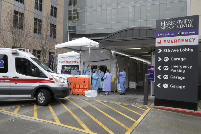 An ambulance pulls up as nurses outside a triage tent for the Emergency Department at the Harborview Medical Center in Seattle put on gowns and other protective gear at the start of their shift, on April 2, 2020. A resurgence of the coronavirus has health care workers and government leaders worried about dwindling resources and an exhausted workforce.