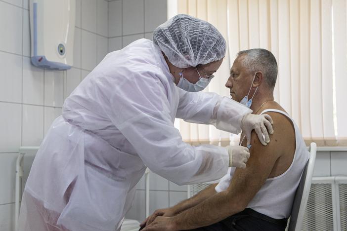 A Moscow health care worker administers a shot of Russia's Sputnik V coronavirus vaccine during clinical trials in September. President Vladimir Putin ordered the nation's health authorities to begin mass vaccinations next week.