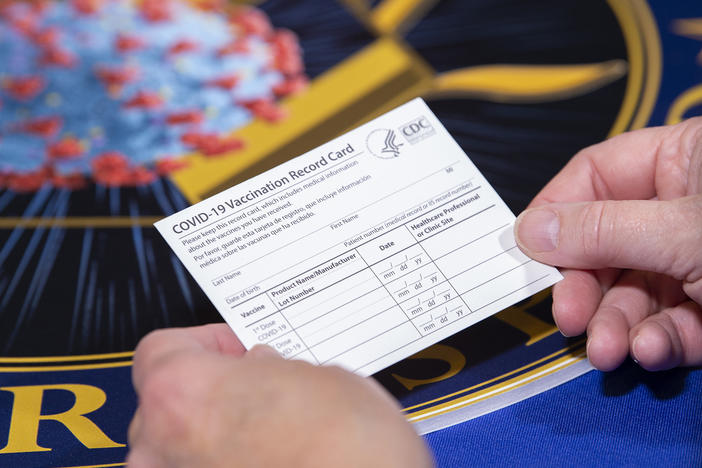 People getting the COVID-19 vaccine will receive a special vaccine card to record their doses, Operation Warp Speed officials say. Here, a Department of Health and Human Services employee holds a sample card.