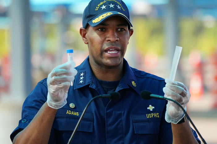 U.S. Surgeon General Jerome Adams demonstrates how to use a COVID-19 self-test kit during a press conference in Atlanta in August.