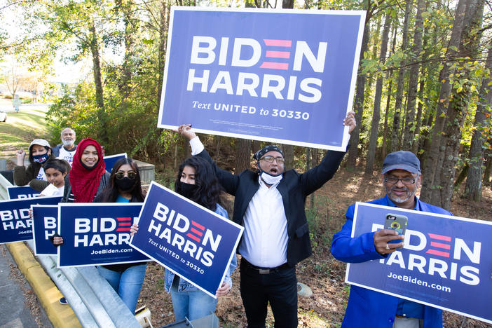 Voters wave Biden-Harris campaign signs at the entrance to a polling station in Gwinnett County, Ga., on Nov 3. Gwinnett is one of the five Atlanta metro counties that saw a dramatic increase in turnout among Asian American and Pacific Island voters this year.