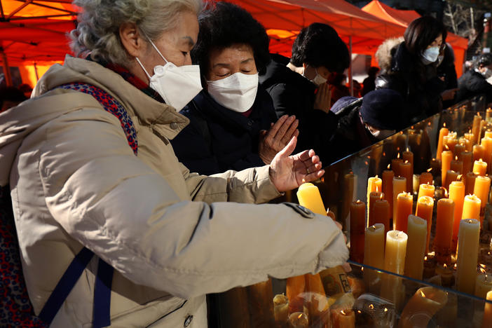 South Koreans pray for their children taking the College Scholastic Ability Test at Chogey temple in Seoul on Thursday. New coronavirus infections in the country have spiked in recent days.