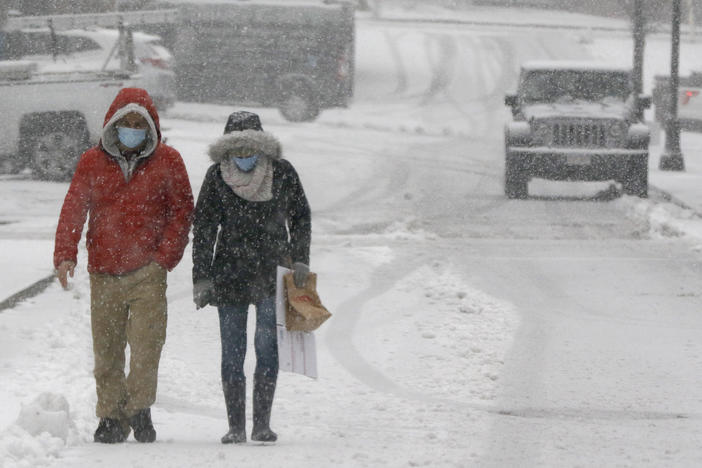 A couple walks through heavy snow on Saturday in downtown Marlborough, Mass. The northeastern United States is seeing the first big snowstorm of the season.
