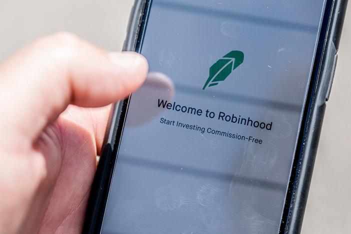 The Robinhood investment app appears on a smartphone in this photo illustration. Day trading has surged during the coronavirus pandemic as stay-at-home people try buying and selling stocks, often for the first time.