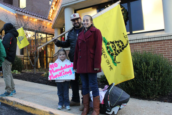 Outside City Hall on the evening of a vote on a proposed mask order in Washington, Mo., residents Ali and Duncan Whittington protest against the order, along with their 4-year-old daughter. "I'm here because I feel my freedom is being violated," Ali says.