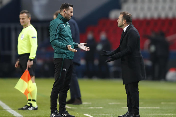 Basaksehir team manager Okan Buruk (right) argues with referee Sebastian Coltescu during a Champions League soccer match between Paris Saint Germain and Istanbul Basaksehir in Paris on Tuesday.