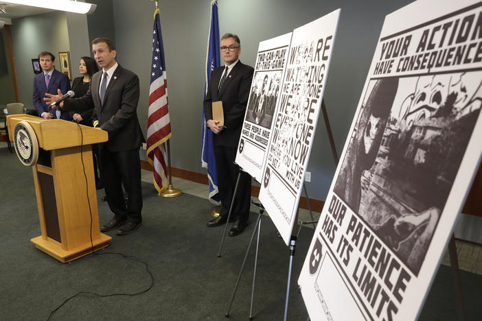 Raymond Duda, FBI Special Agent in Charge in Seattle, speaks in February about charges against a group of alleged members of the neo-Nazi group Atomwaffen Division for cyber-stalking and mailing threatening communications, including the posters at right, in a campaign against journalists in several cities.