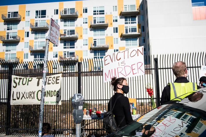A demonstrator holds a sign in the Mission in San Francisco on Nov, 16 calling for shelter-in-place hotel rooms to remain available for unhoused residents.