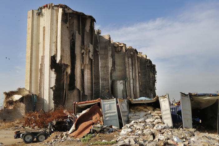 Shattered containers remain in front of towering grain silos gutted in the August explosion at the Beirut port that claimed the lives of more than 200 people.