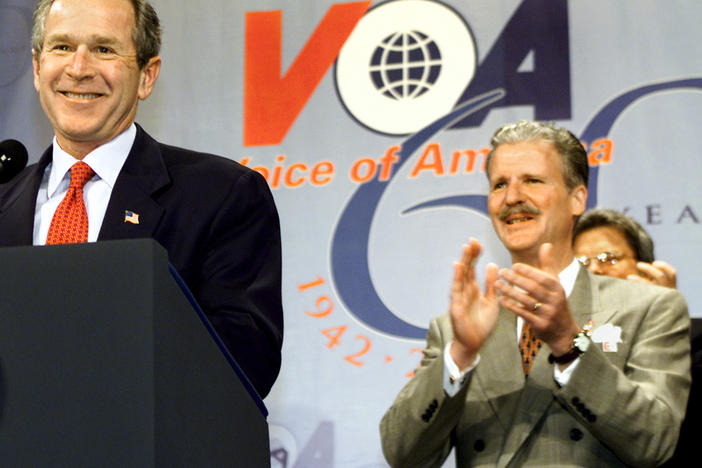 Robert R. Reilly led Voice of America briefly under President George W. Bush. Here they're shown at a VOA anniversary celebration in February 2002.