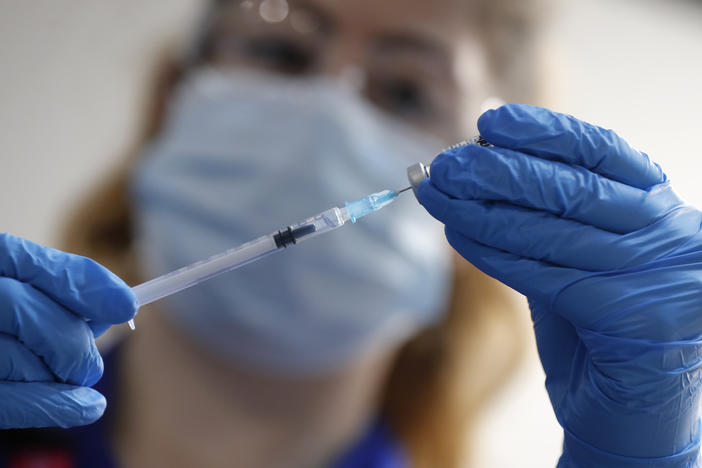 A nurse prepares to administer the Pfizer-BioNTech COVID-19 vaccine at a hospital in London on Tuesday. The Food and Drug Administration is considering a recommendation to authorize the vaccine in the United States.