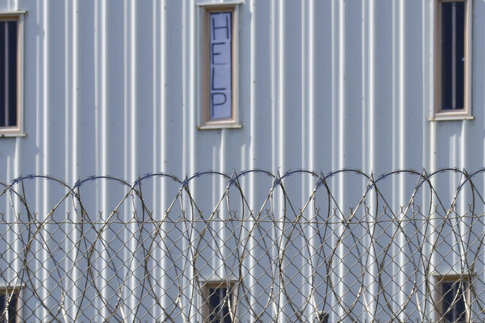 A sign reading "HELP" is posted in the window of an inmate's cell during a 2019 tour with state officials at Holman Correctional Facility in Atmore, Ala.