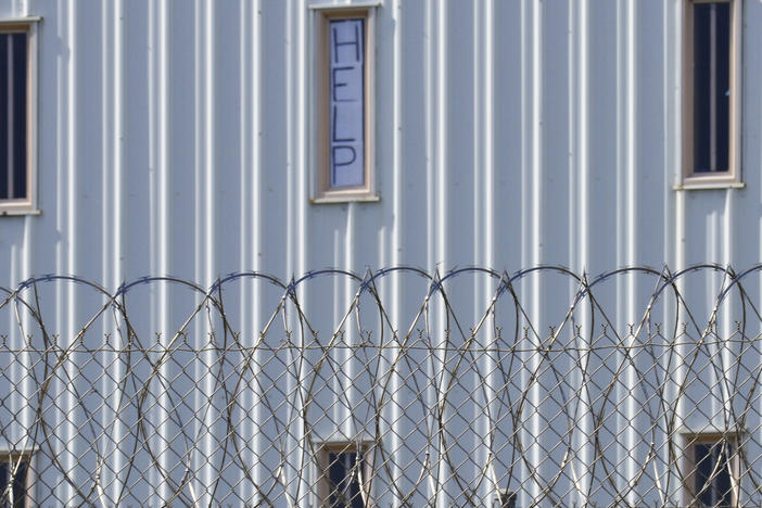 A sign reading "HELP" is posted in the window of an inmate's cell during a 2019 tour with state officials at Holman Correctional Facility in Atmore, Ala.