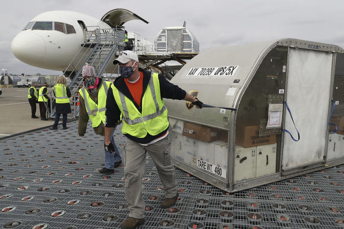 Two shipping containers holding the first doses of the Pfizer and BioNTech COVID-19 vaccine arrived at the UPS Worldport in Louisville, Ky., on Sunday.