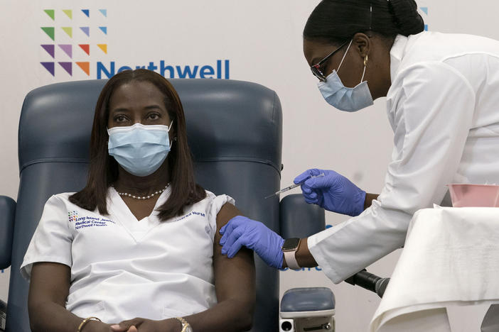 Sandra Lindsay (left) a nurse at Long Island Jewish Medical Center, is inoculated with the Pfizer-BioNTech COVID-19 vaccine by Dr. Michelle Chester on Monday in New York.