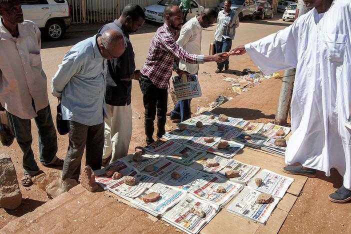 People in Sudan's capital, Khartoum, browse newspapers with headlines featuring the 2020 U.S. general election results. After 27 years, the State Department has removed Sudan from a list of state sponsors of terrorism.