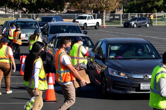 Food is loaded as drivers in their vehicles wait in line at a food distribution hosted by the Los Angeles Food Bank on Dec. 4 in Hacienda Heights, Calif.