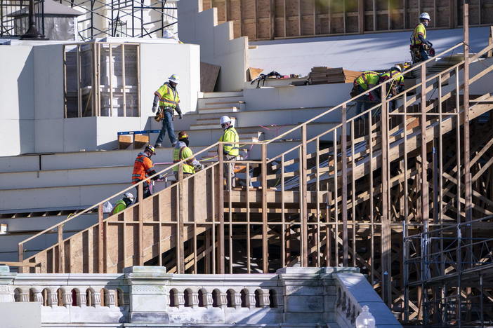 Construction crews work on the platforms where President-elect Joe Biden will take the oath of office at the Capitol in Washington.
