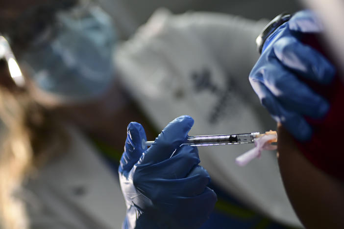 Nurse Melissa Valentin applies the Pfizer-BioNTech COVID-19 vaccine to a health worker at the Ashford Presbyterian Community Hospital in San Juan, Puerto Rico, Tuesday. The vaccine was granted emergency use authorization last week.