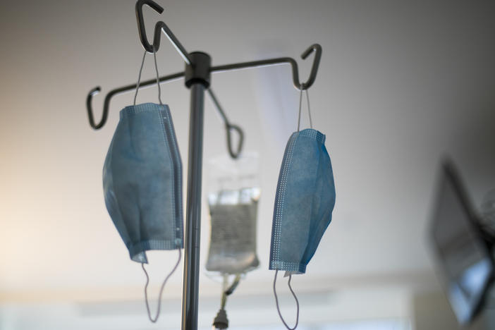 Masks hang from an IV pole at a hospital.
