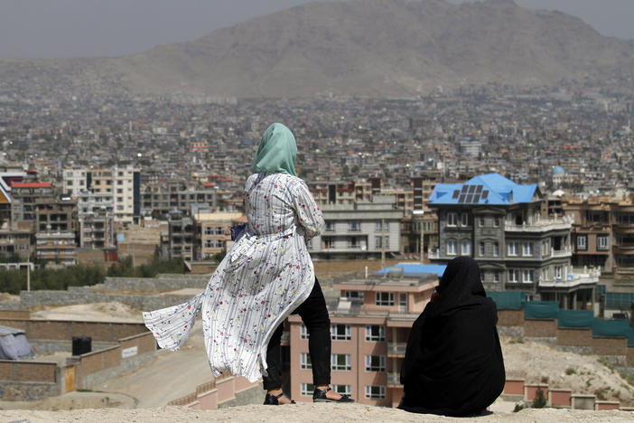 Afghan women look at the skyline of Kabul in September.