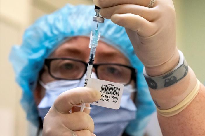 A health care worker prepares COVID-19 vaccine doses at the Portland Veterans Affairs Medical Center on Wednesday in Portland, Ore. Hospitals across the U.S. began getting their first doses of Pfizer's vaccine this week.