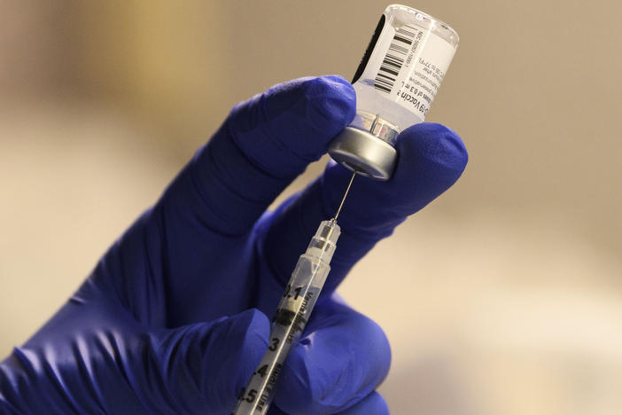 A pharmacist fills a syringe to prepare a dose of the Pfizer-BioNTech vaccine for front-line health care workers in Torrance, Calif., on Saturday. A panel of CDC advisers said people 75 and older and some essential workers should be next in line.