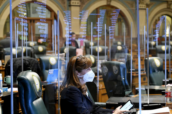 Colorado state Rep. Julie McCluskie, a Democrat, is surrounded by protective plastic barriers in the House chambers at the Colorado State Capitol during an emergency legislative session on November 30. Lawmakers there are planning to move their 2021 session back by at least a month.