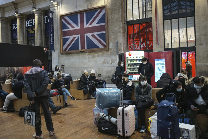 Passengers wearing face masks wait next to the Eurostar Terminal at Gare du Nord train station in Paris on Monday. France is banning all travel from the U.K. for 48 hours in an attempt to make sure a new strain of the coronavirus in Britain doesn't reach its shores.