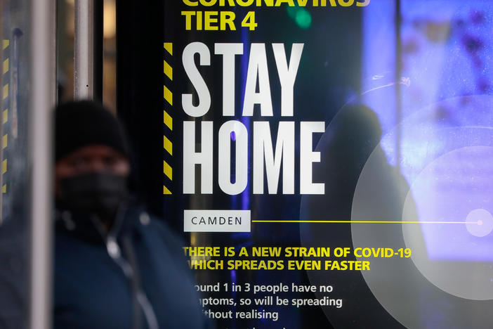 A poster about the new, fast-spreading variant of the coronavirus warns some Britons to stay home. The sign is displayed near King's Cross railway station in London.