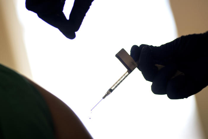 A droplet falls from a syringe after a health care worker was injected with the Pfizer-BioNTech COVID-19 vaccine at Women & Infants Hospital in Providence, R.I.