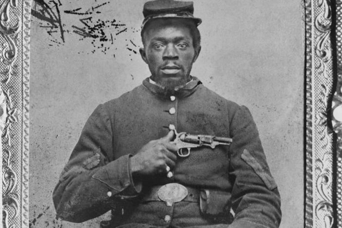 Negro Union Infantry corporal, holding a Colt model 1849 pocket revolver.