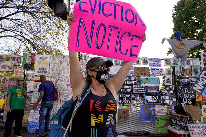 A protester holds up an eviction-related sign in Washington, D.C. The coronavirus rescue package just passed in Congress sets aside $25 billion for rental assistance and extends a CDC order aimed at preventing evictions.