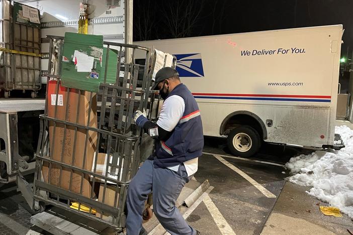 Like many of his colleagues, postal worker Rickey Ramirez is working overtime to keep up with the crush of Christmas deliveries. Many packages are likely to be delivered after Dec. 25.