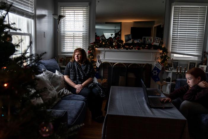 Eileen Carroll, left, sits for a portrait as her daughter, Lily, 11, attends school remotely from their home in Warwick, R.I. on Dec. 16. When Carroll's other daughter tested positive for the coronavirus, state health officials told her to notify anyone her daughter might have been around. Contact tracers, she was told, were simply too overwhelmed to do it.