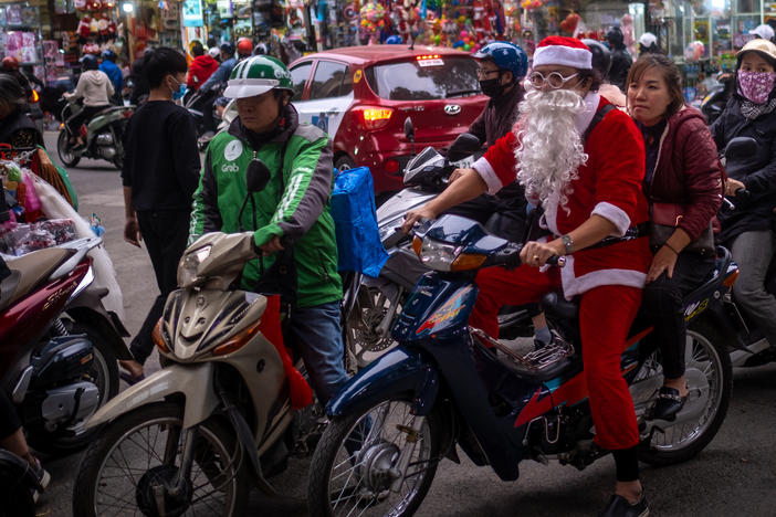 A man in a Santa Claus costume rides a motorbike in the Old Quarter on Dec. 24, 2020, in Hanoi, Vietnam.