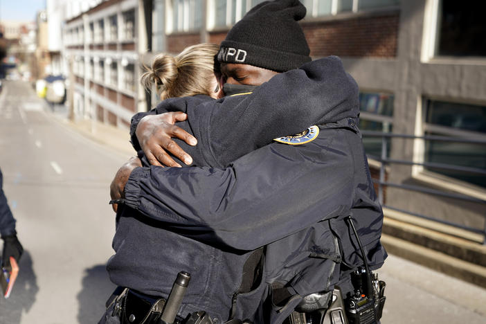 Nashville, Tenn., police officers Brenna Hosey and James Wells embrace after speaking at a news conference on Sunday. Hosey and Wells are part of a group of officers credited with evacuating people before the explosion that occurred in downtown Nashville early Christmas morning.